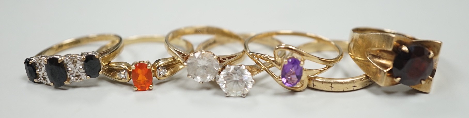 Six assorted modern 9ct gold and gem set rings, including amethyst and garnet single stone rings, together with a 9ct gold wedding band, gross weight 15.2 grams.